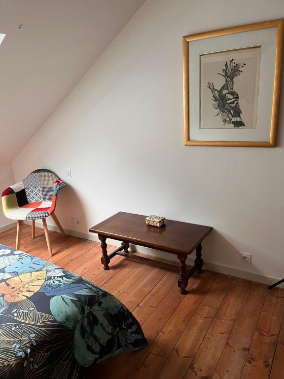 um quarto com uma cama, uma mesa e uma cadeira em Duplex terrasse em Frehel