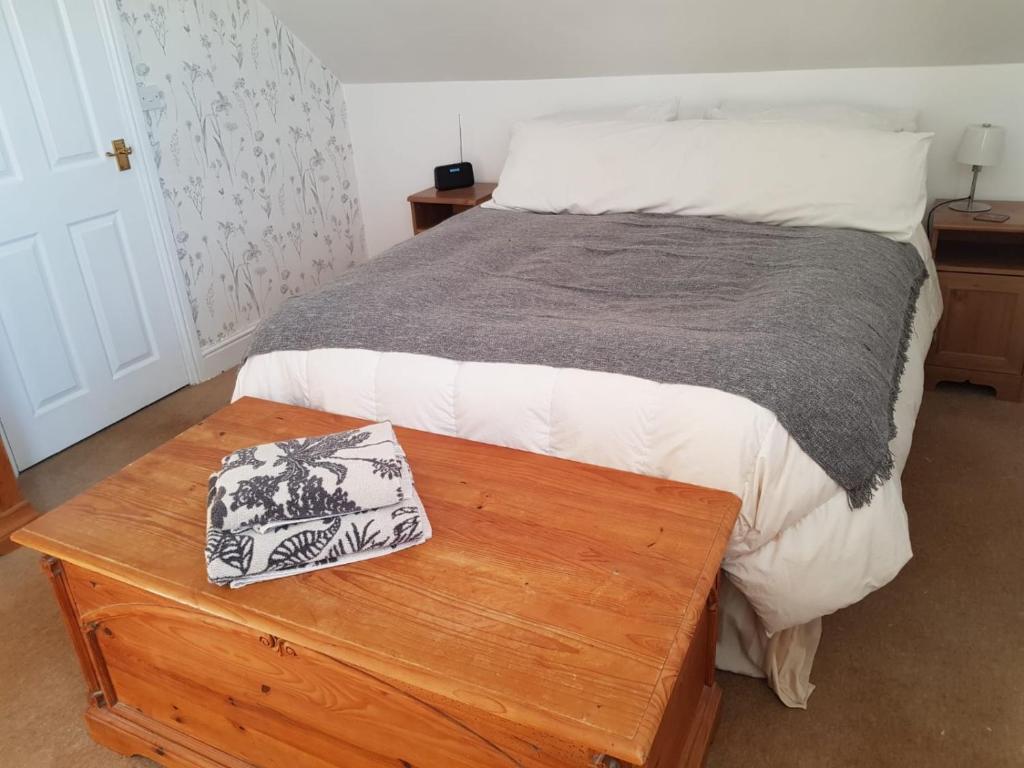 a bedroom with a bed with a wooden table at Minook in Thorney