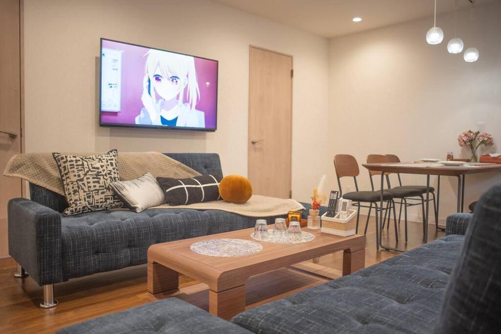 - un salon avec un canapé et une télévision murale dans l'établissement 银座合之屋 筑地市场地铁三分钟 银座徒步十分钟, à Tokyo