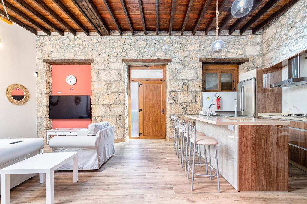 cocina y sala de estar con barra y taburetes en CASA EL ROQUE, en Telde
