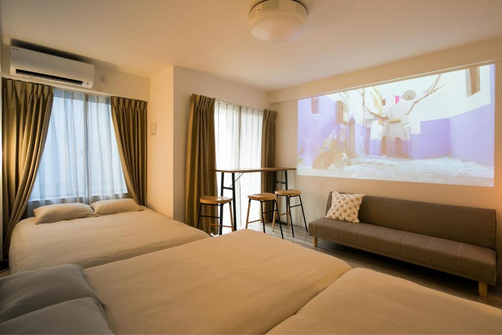 een hotelkamer met twee bedden en een groot aquarium bij trive meieki nishi 106 最大6名宿泊可 名古屋駅まで1駅 太閤通駅徒歩4分 角部屋 無料駐車場付き in Nagoya