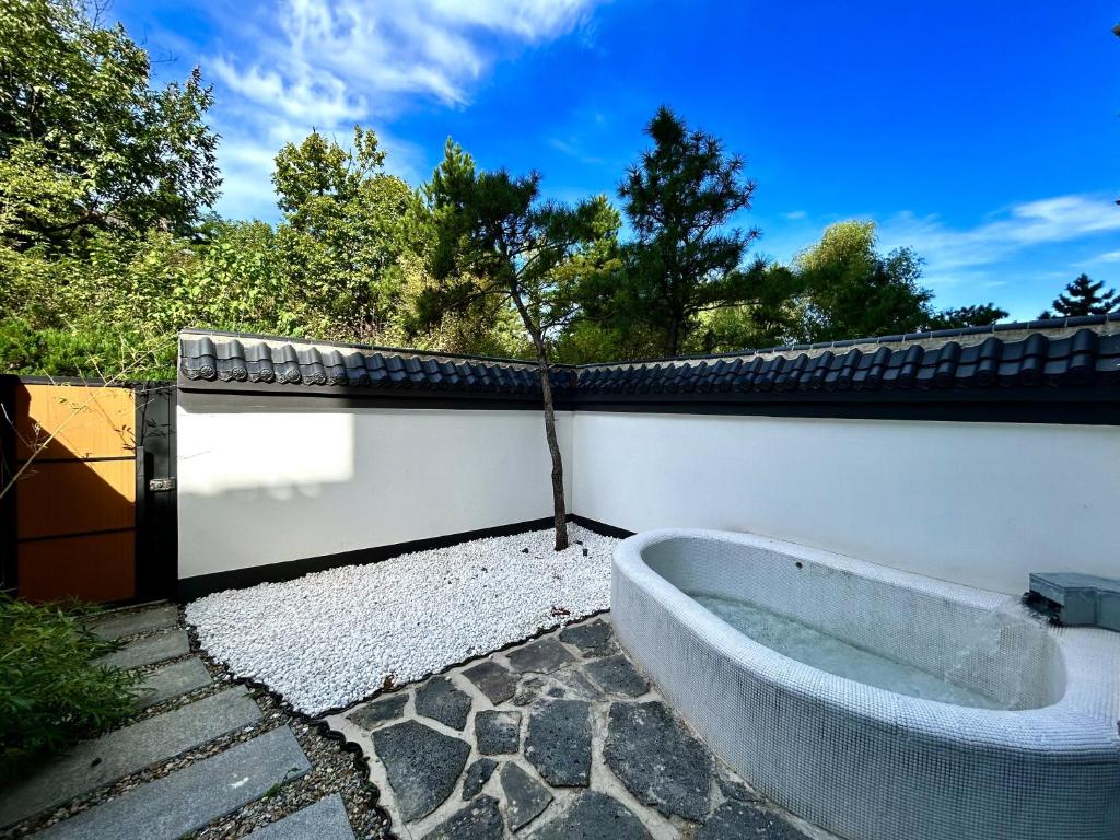 a bath tub sitting next to a white wall at Rainbow Valley Hot Spring Hotel in Gaizhou