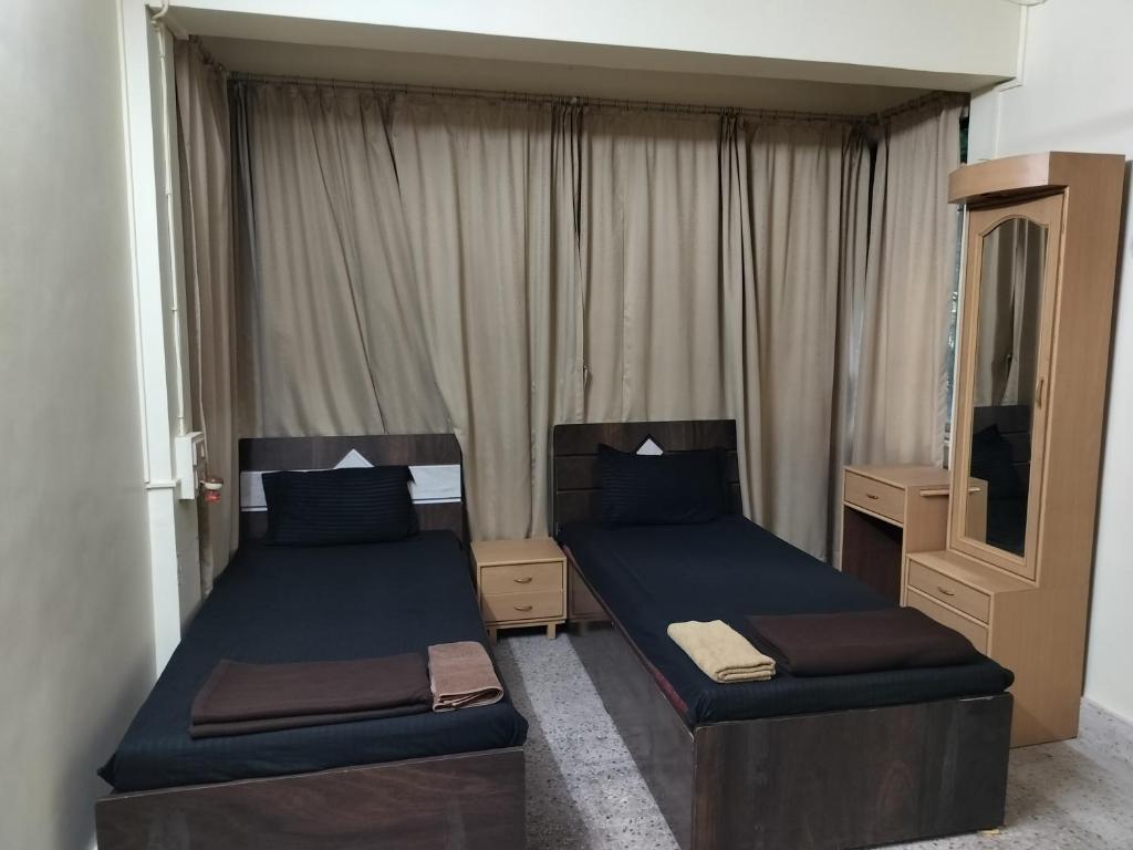 a bedroom with two beds and a mirror at A & P Apartments in Thane