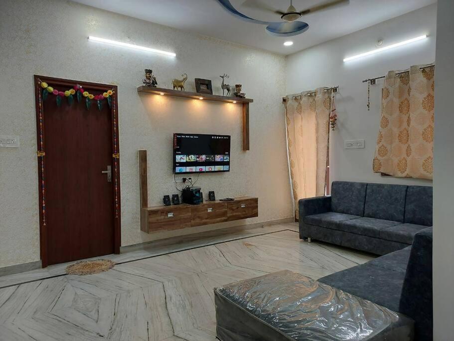 a living room with a couch and a tv at Entire Villa in Jodhpur