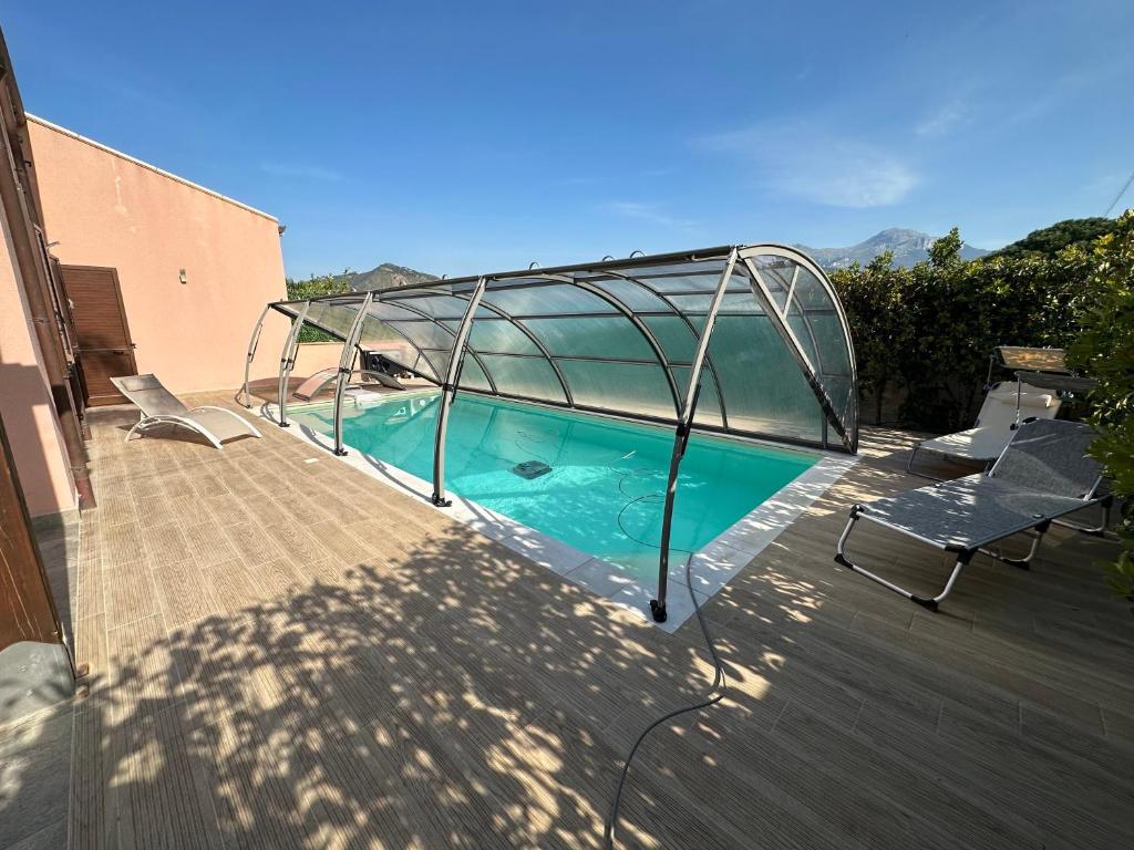 a swimming pool with a glass enclosure on a deck at Villa con piscina riscaldata ad uso esclusivo, aperta tutto l'anno in Lascari