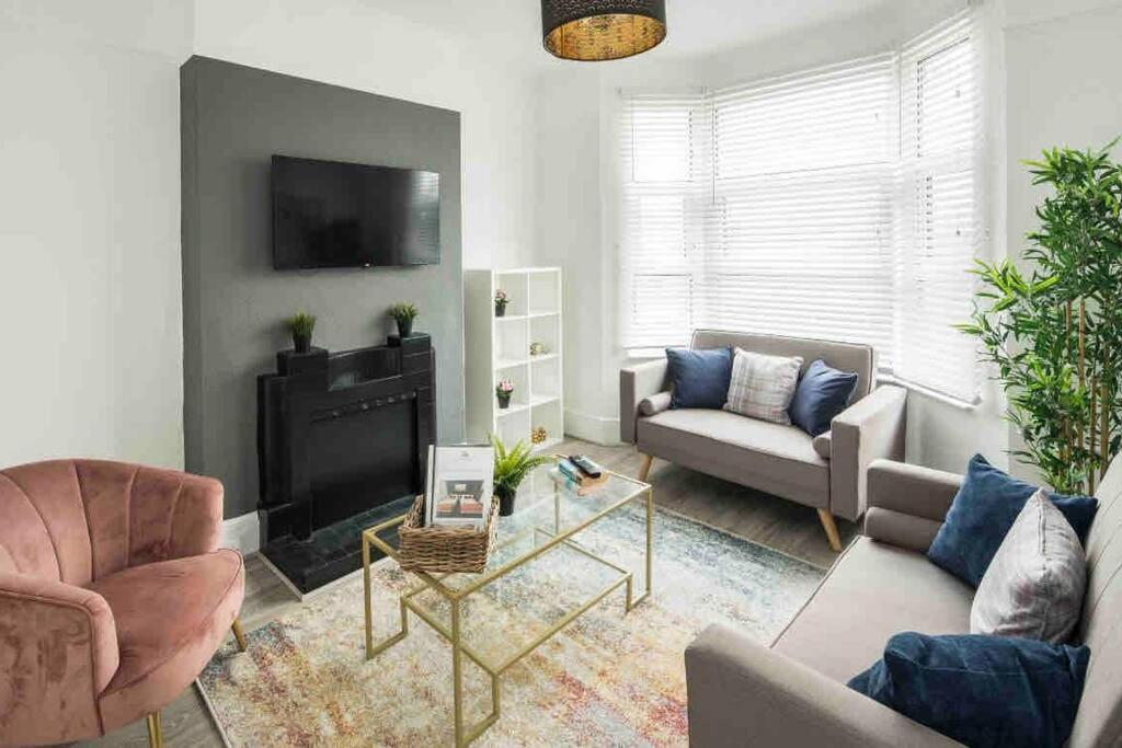 a living room with two couches and a fireplace at Pleasant 4 bed house with x6 beds in heart of Croydon !! - Photo ID Required in Croydon