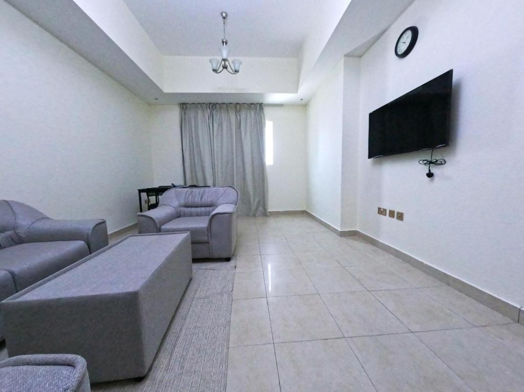 un soggiorno con divani e TV a schermo piatto di Barsha Star Residence - Home Stay a Dubai