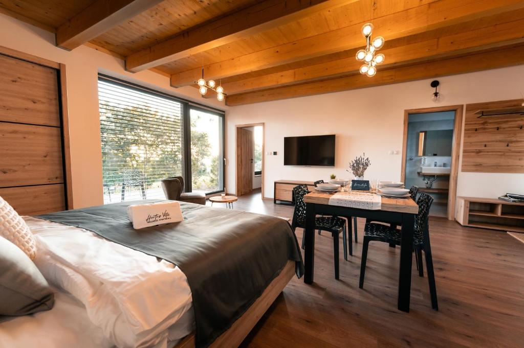 um quarto com uma cama, uma mesa e uma televisão em Hortus Vita Wellness Apartments em Lipnice nad Sázavou