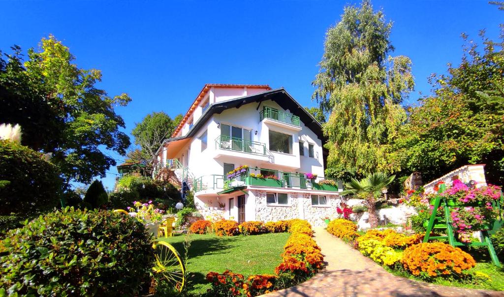 ein weißes Haus mit einem Garten davor in der Unterkunft Villa Forest Paradise in Ohrid