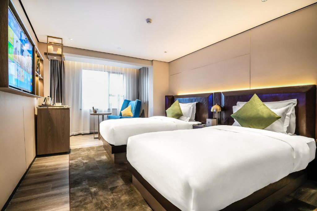 Habitación de hotel con 2 camas y TV de pantalla plana. en 宜尚Plus酒店广州北京路步行街店, en Guangzhou