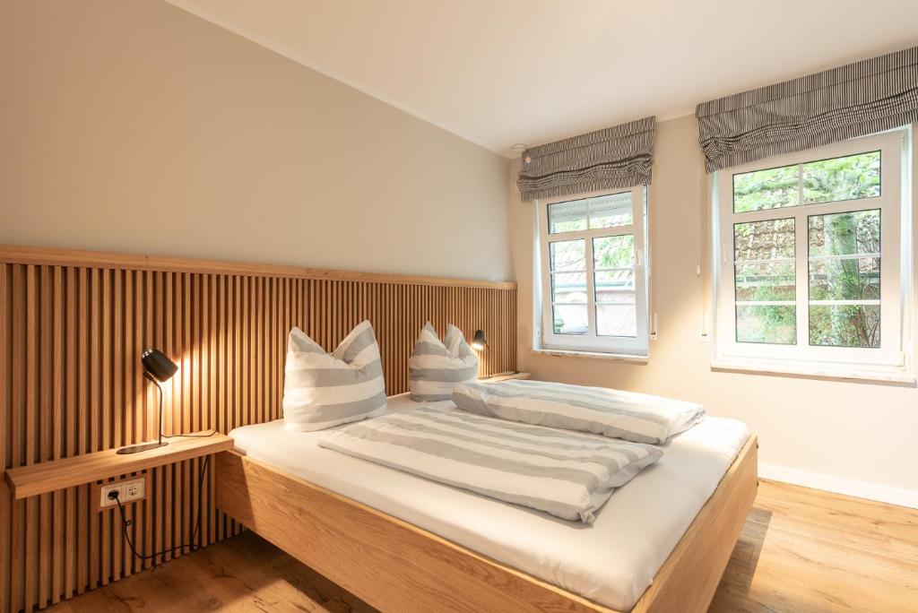 a bedroom with a large bed and two windows at Familienhaus am Meer in Dornum