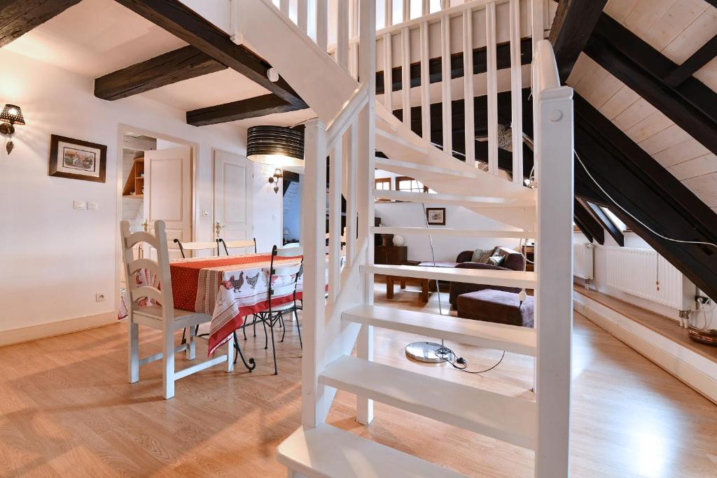 une cuisine et une salle à manger avec un escalier en colimaçon blanc. dans l'établissement Au Nid d'Hirondelles, à Ribeauvillé