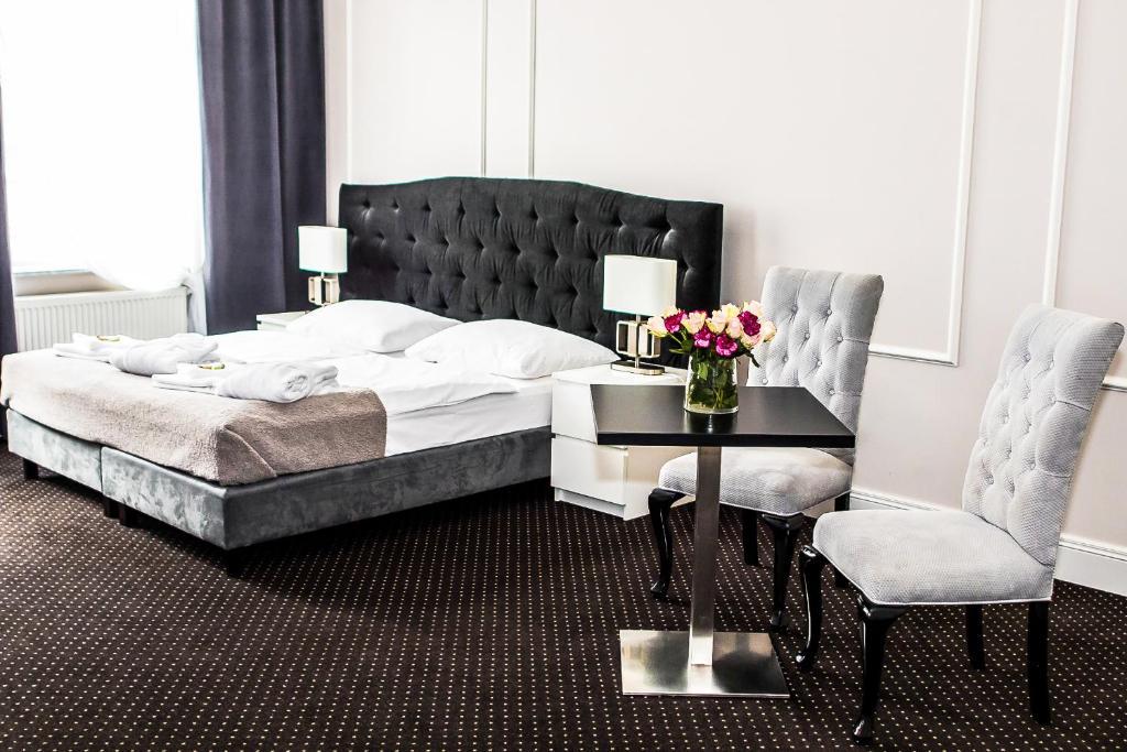 a bedroom with a bed and a table and chairs at Aparthotel Platinum Apartamenty in Inowrocław