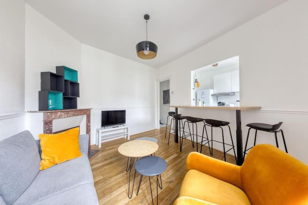 een woonkamer met een bank en een tafel bij Appartement entier au coeur de Nogent Sur Marne in Nogent-sur-Marne