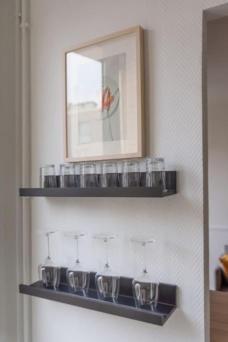 a row of glasses on a shelf in a room at Appartement entier au coeur de Nogent Sur Marne in Nogent-sur-Marne