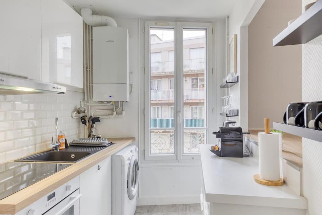 a white kitchen with a sink and a window at Appartement entier au coeur de Nogent Sur Marne in Nogent-sur-Marne