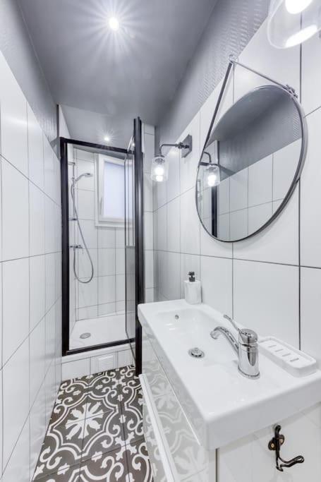 a white bathroom with a sink and a mirror at Appartement entier au coeur de Nogent Sur Marne in Nogent-sur-Marne