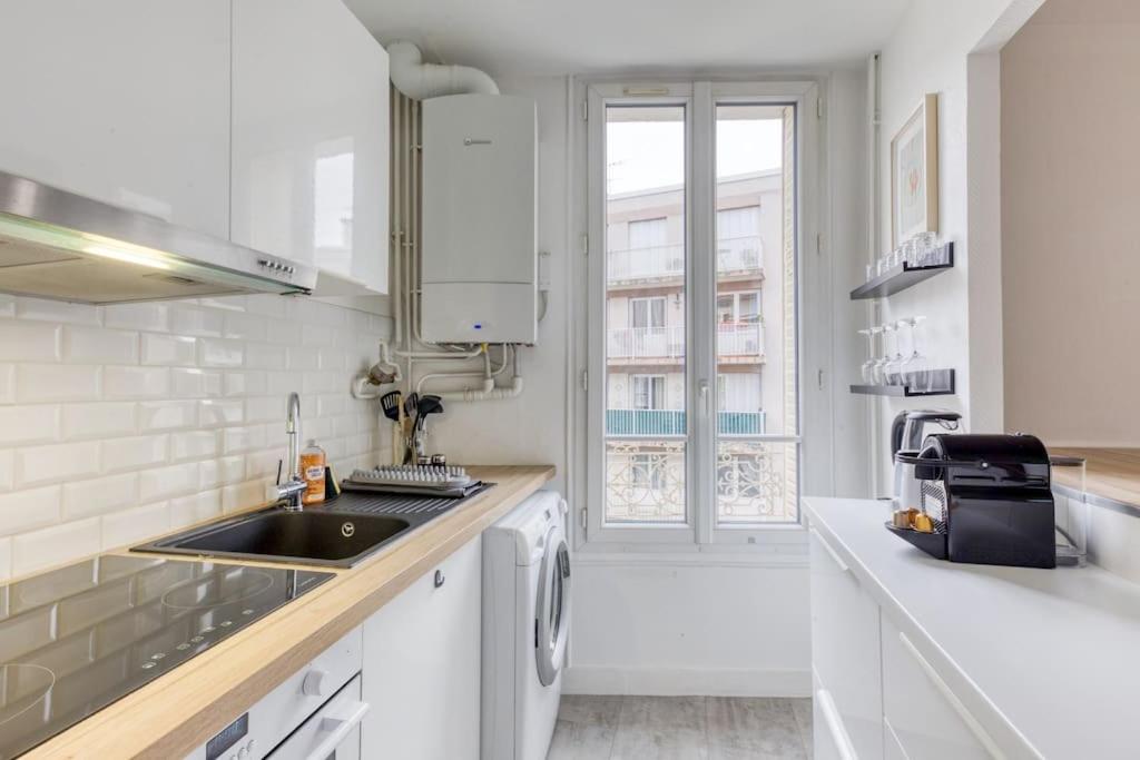a white kitchen with a sink and a dishwasher at Appartement entier au coeur de Nogent Sur Marne in Nogent-sur-Marne