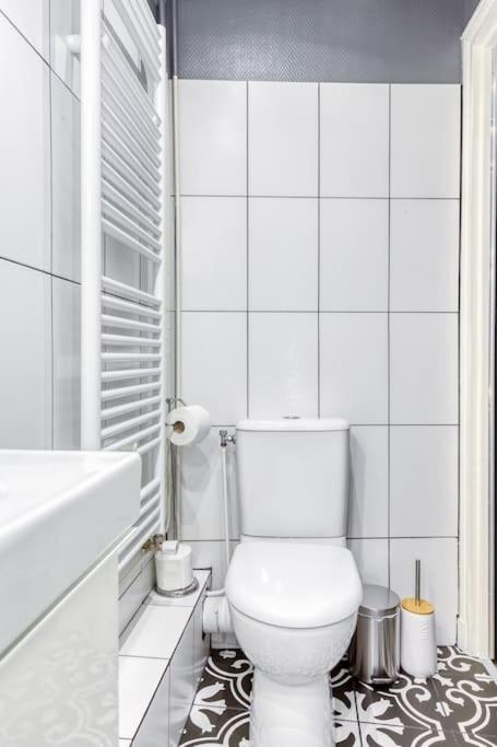 a white bathroom with a toilet and a tub at Appartement entier au coeur de Nogent Sur Marne in Nogent-sur-Marne