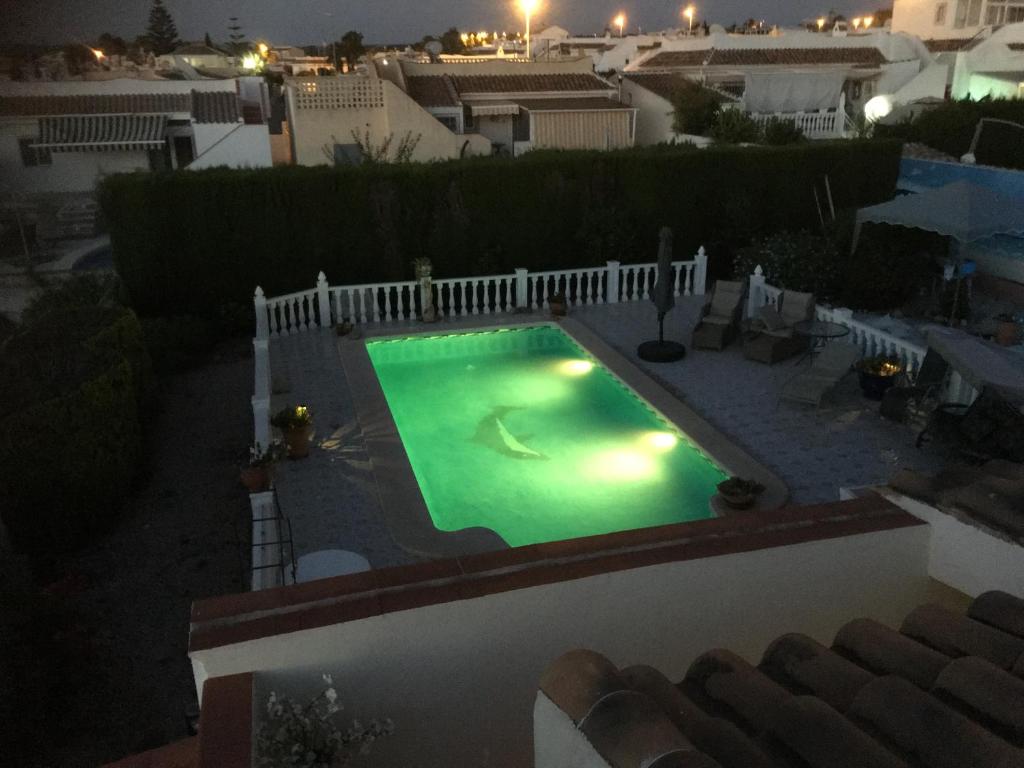una piscina en un patio trasero por la noche en Casita Relaks en Camposol
