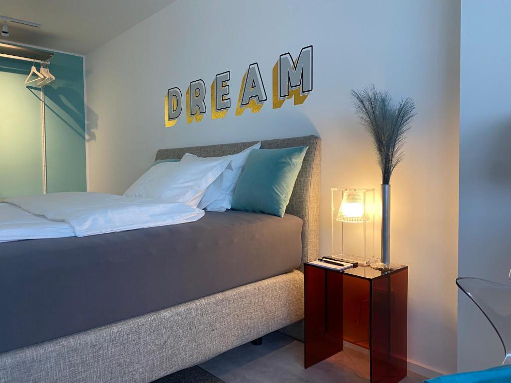 a bedroom with a bed with a dream sign on the wall at SIR WALTER Work & Stay, HOMEOFFICE, W-LAN in Neuss