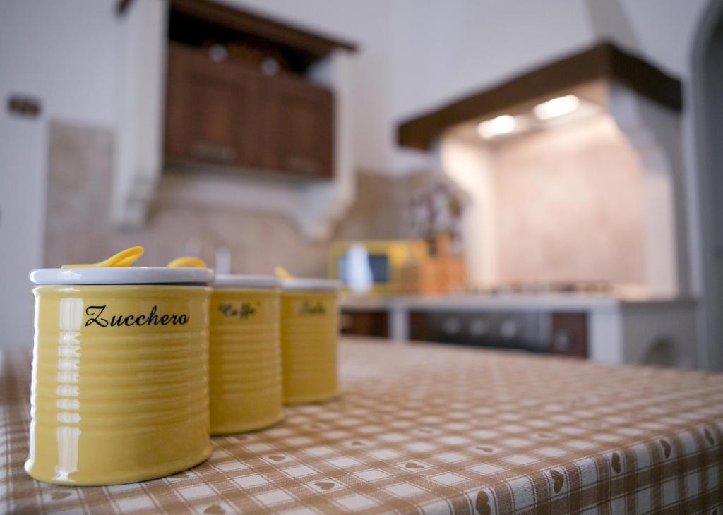 trois tasses jaunes assises sur un comptoir dans une cuisine dans l'établissement Marconi by PizzoApartments, à Pizzo