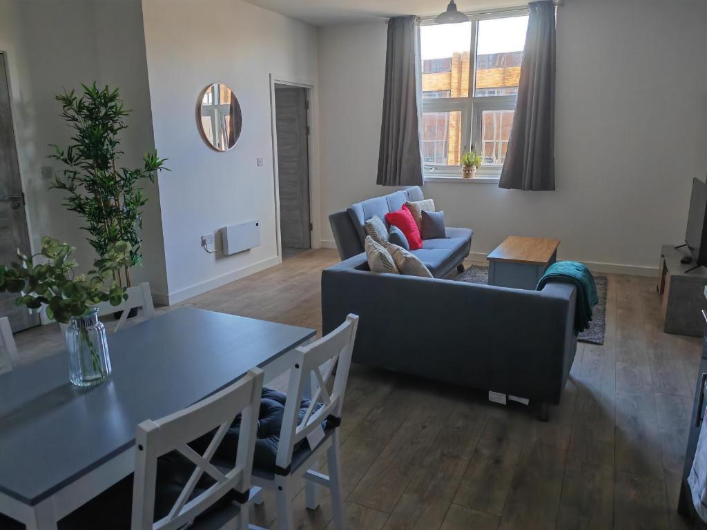 uma sala de estar com um sofá e uma mesa em Modern Two Bedroom Apartment - Central Peterborough em Peterborough