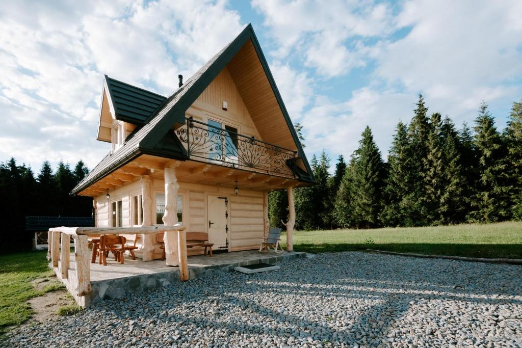 a log cabin with a balcony and a patio at Domek pod lasem in Klikuszowa