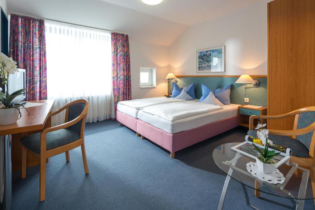 a hotel room with a bed and a desk at Gästehaus Gelsenkirchen in Norderney