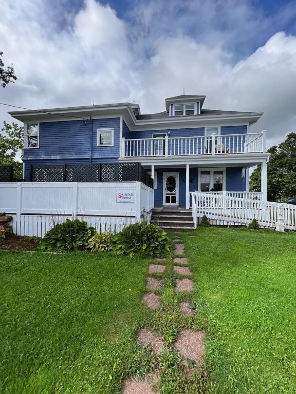 a blue house with a white fence and a yard at The Home Place Inn in Kensington