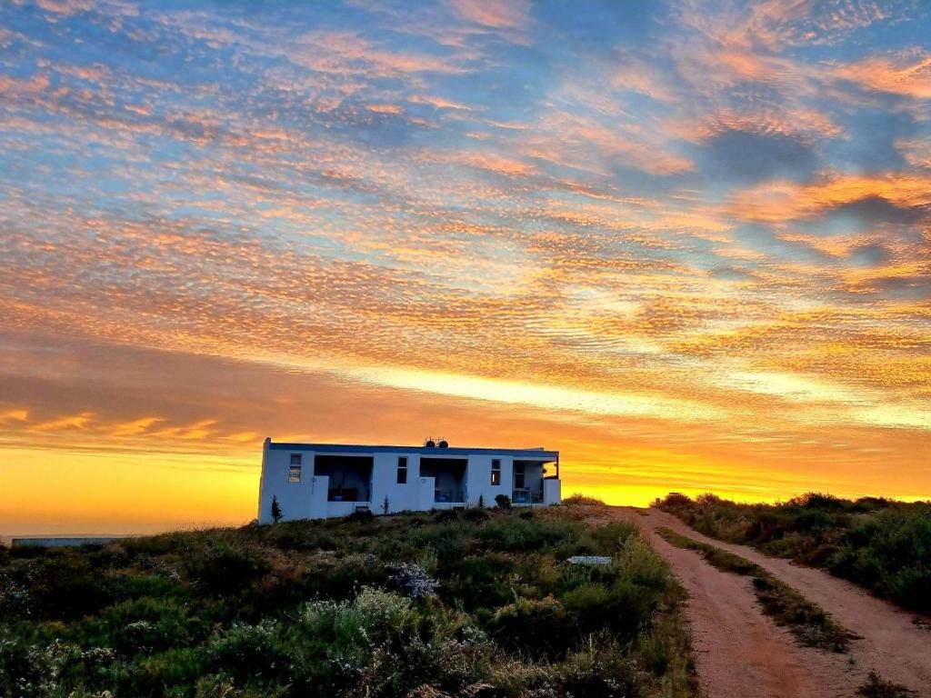 a house on top of a hill with a dirt road at The Daiquiri Shaq in St Helena Bay