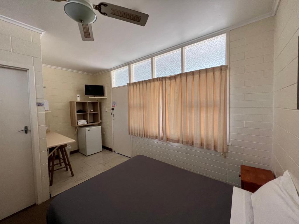 Zimmer mit einem Bett und einem Fenster mit einem Schreibtisch in der Unterkunft Glossop Motel in Winkie