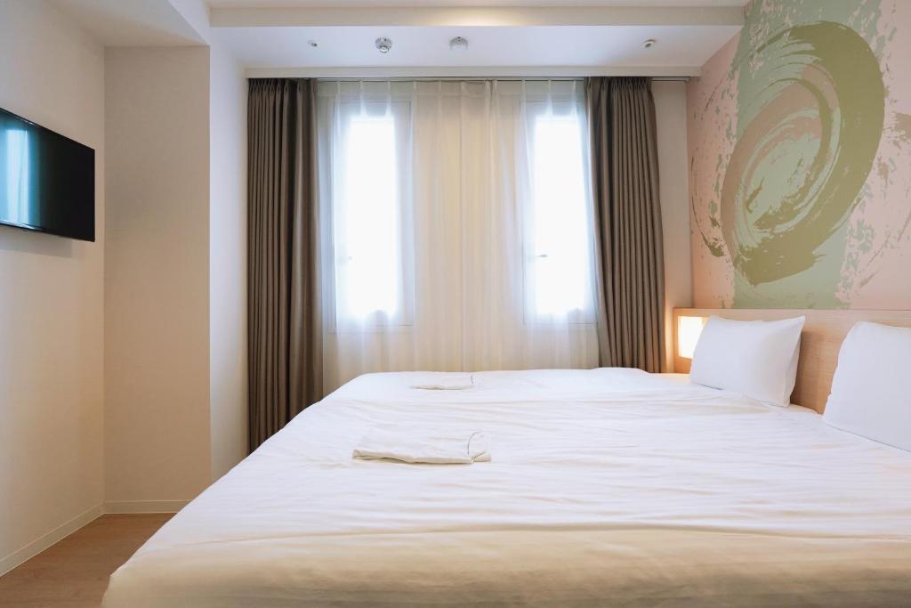 Postel nebo postele na pokoji v ubytování Park Central Sakura Hotel