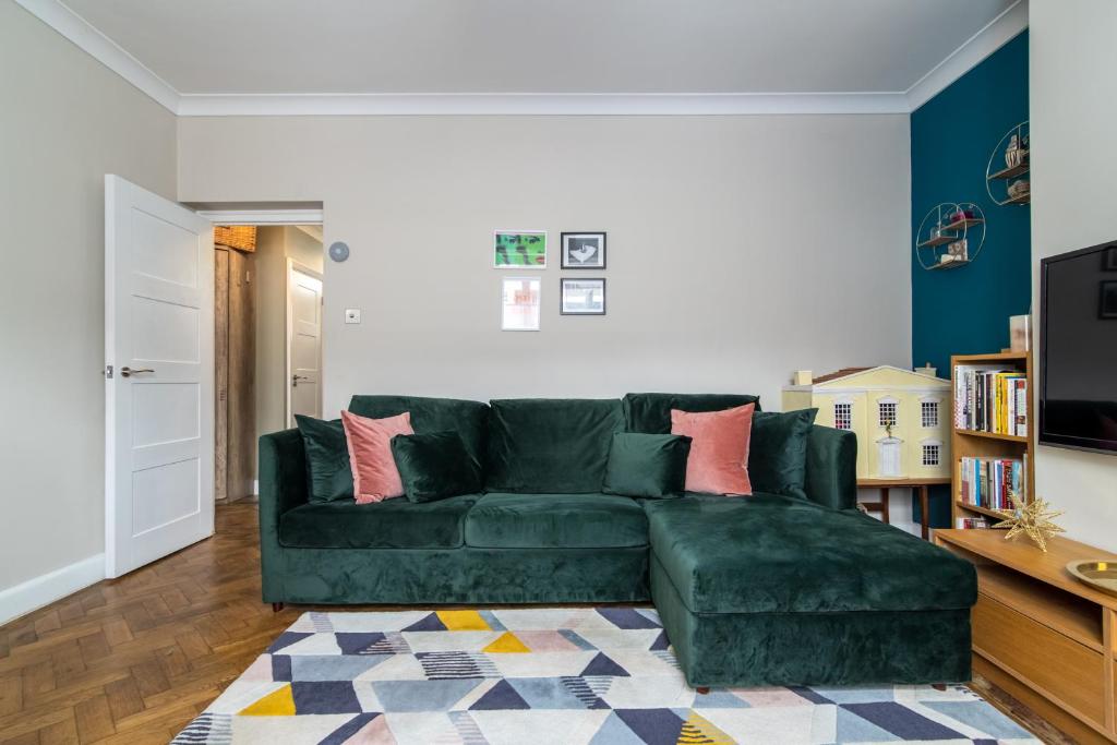 ein Wohnzimmer mit einer grünen Couch in einem Zimmer in der Unterkunft Central London 1 BR Apt in Vauxhall near Big Ben in London
