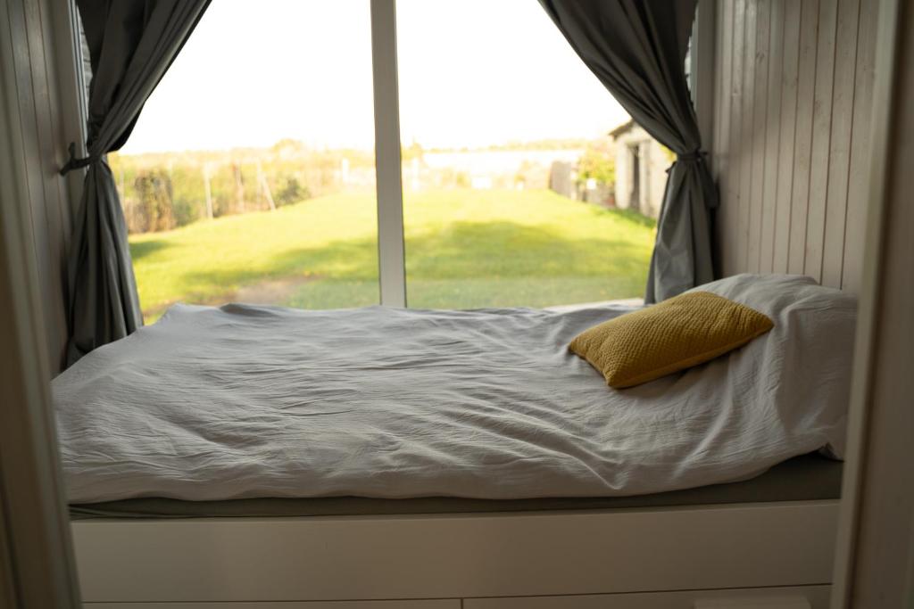 Una cama en una ventana con una almohada. en Charmante la petite maison, en Potsdam