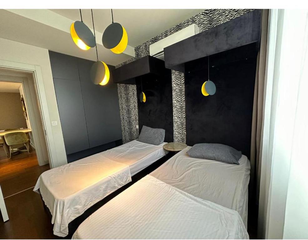 MERKEZİ HUZURLU في إسطنبول: سريرين في غرفة ذات إضاءة صفراء