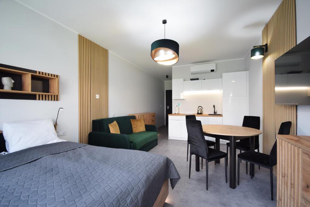 sypialnia z łóżkiem, stołem i krzesłami w obiekcie Apartament Royal Solny Resort z aneksem kuchennym w hotelu z krytym basenem, sauną i usługami SPA w Kołobrzegu