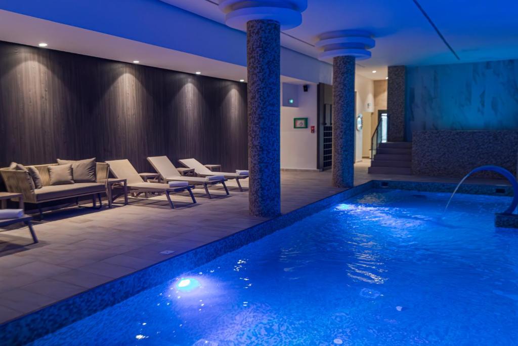 a hotel lobby with a swimming pool and chairs at BOUMERDES PLAZA Hôtel & Spa in Boumerdes