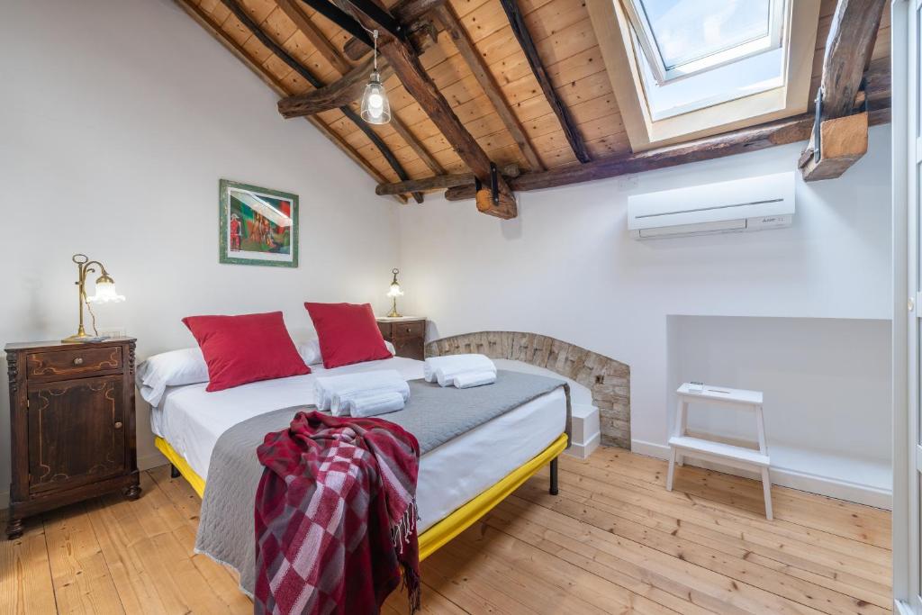Un dormitorio con una cama con almohadas rojas. en A Casa di Gianna, en Cagliari