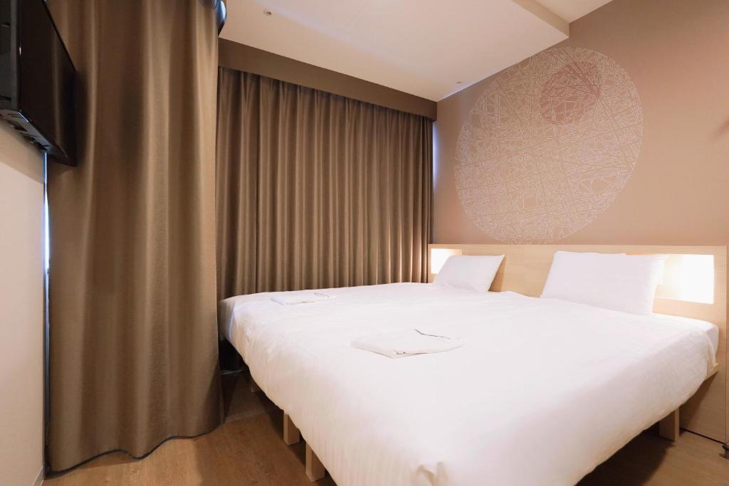Postel nebo postele na pokoji v ubytování Park Central Sakura Hotel