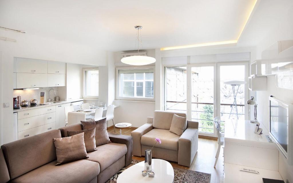 sala de estar con sofá y sillas y cocina en Nuru Ziya Suites, en Estambul