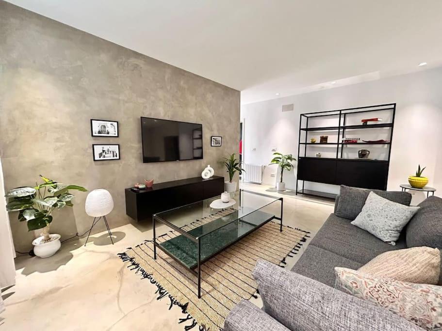 a living room with a couch and a tv at Baïa Appartment in La Marsa