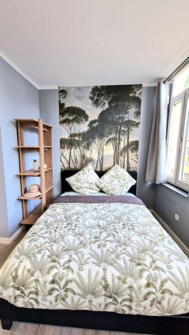 une chambre avec un lit avec un tableau sur le mur dans l'établissement Appartement Hypercentre 203 + WIFI +INDEPENDANT+TOILETTE CUISINE SALLE DE BAIN PRIVATIVE, à Valenciennes