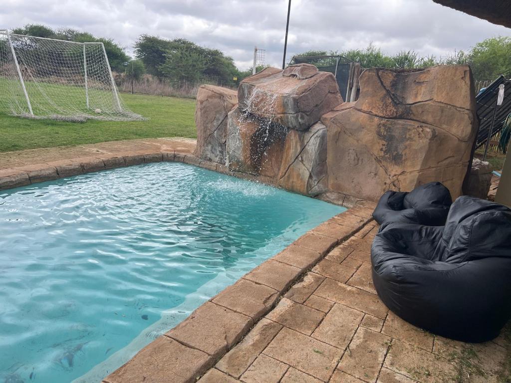 a swimming pool with an inflatable ball and a water fall at Eids Farm in Mmukubyane