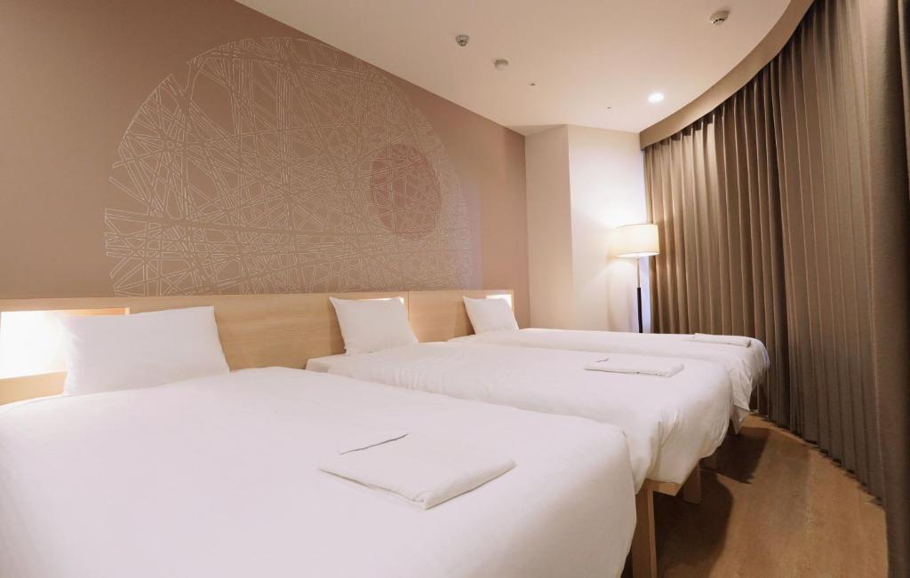 Postel nebo postele na pokoji v ubytování Park Central Sakura Hotel