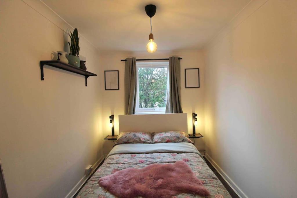 Un dormitorio con una cama con una manta rosa. en The Eagles Nest, en Norwood