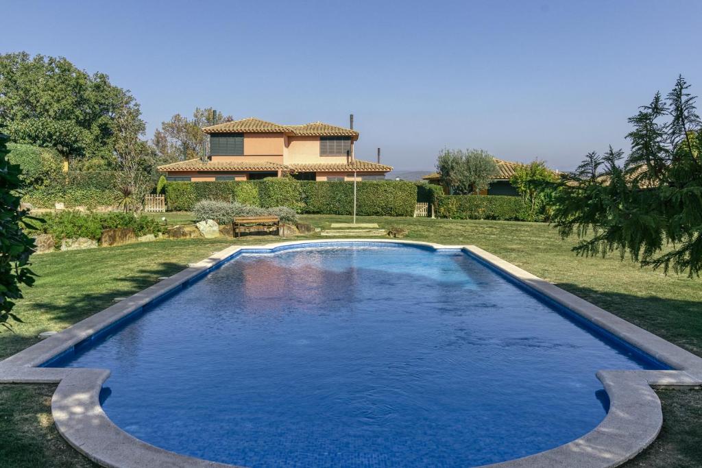 een zwembad in een tuin met een huis op de achtergrond bij Villa Valerie in Navata