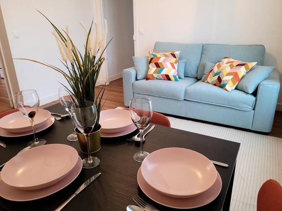 una sala de estar con una mesa con platos y copas de vino en Appartement JO proche Paris,CDG,Expo, Stade de France, en Aulnay-sous-Bois