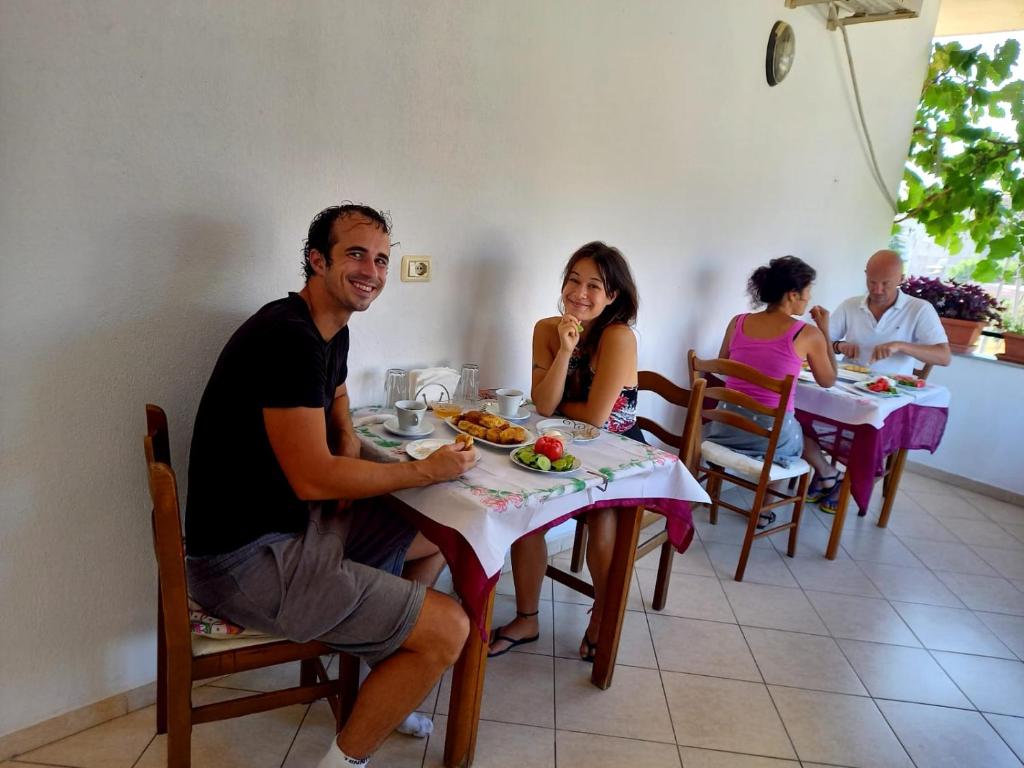 a group of people sitting at a table in a restaurant at GuestHouseMantho in Gjirokastër