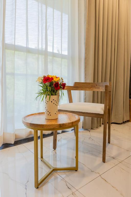 a vase of flowers sitting on a table next to a chair at SURAMYA-A Luxury Boutique Hotel in Udaipur